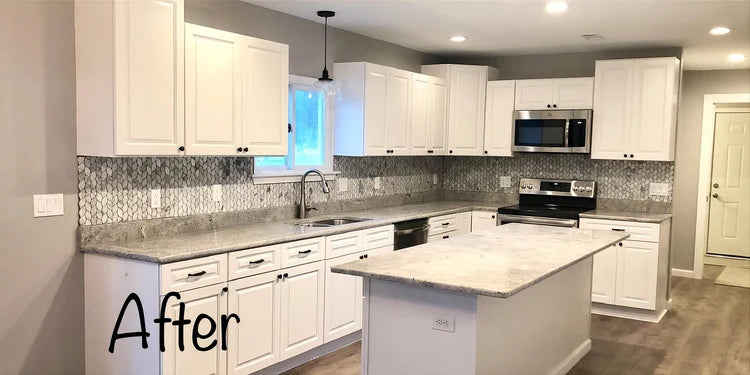 Modern kitchen with white cabinets, marble countertops, and stainless steel appliances.