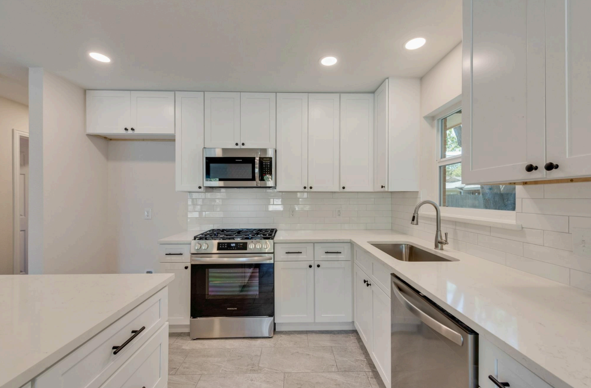 Modern kitchen with white cabinets, stainless steel appliances, and a tiled backsplash ( USA Cabinets Outlet )